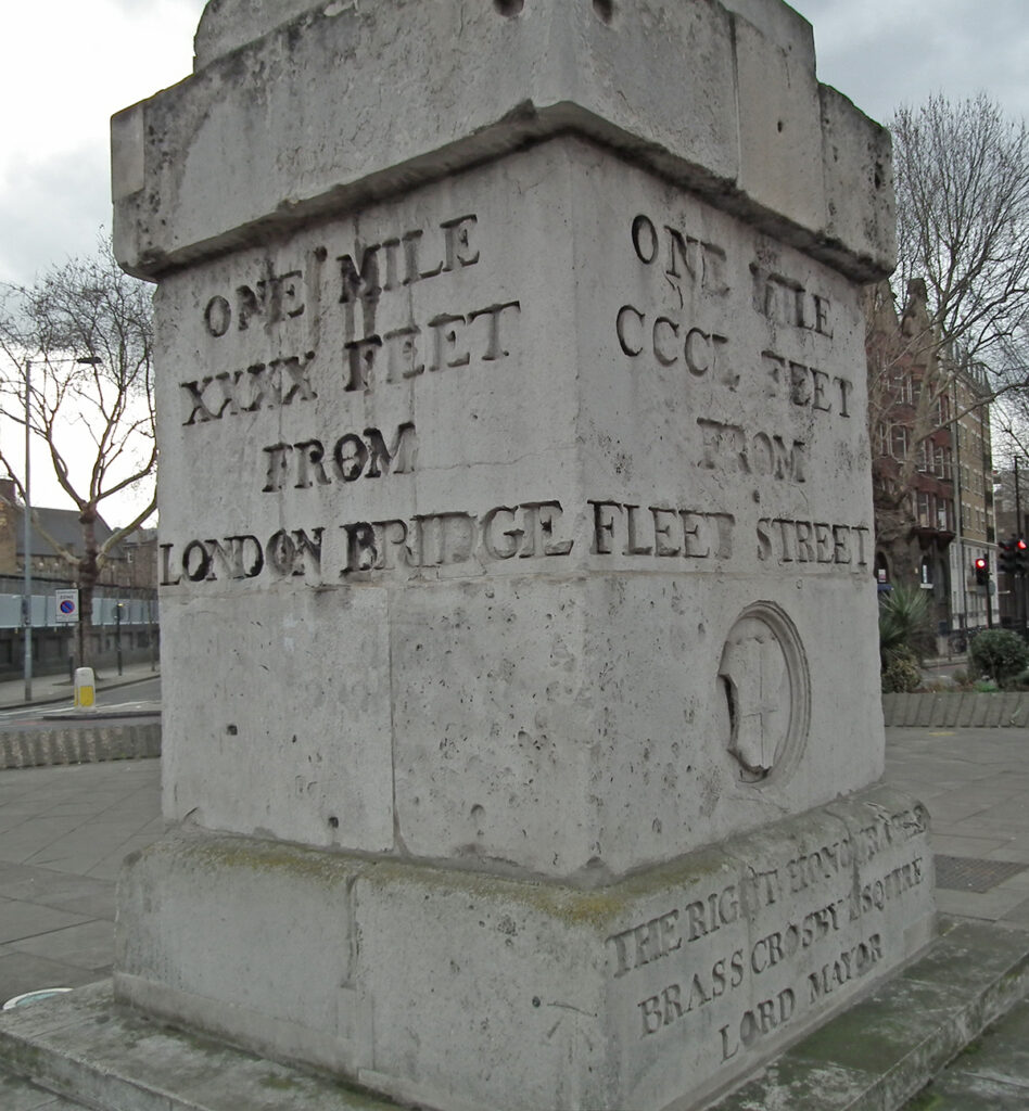 Stone pediment of an 18th century obelisk - inscription reads one mile xxxxx feet from London Bridge, One mile CCCL feet from Fleet Street 