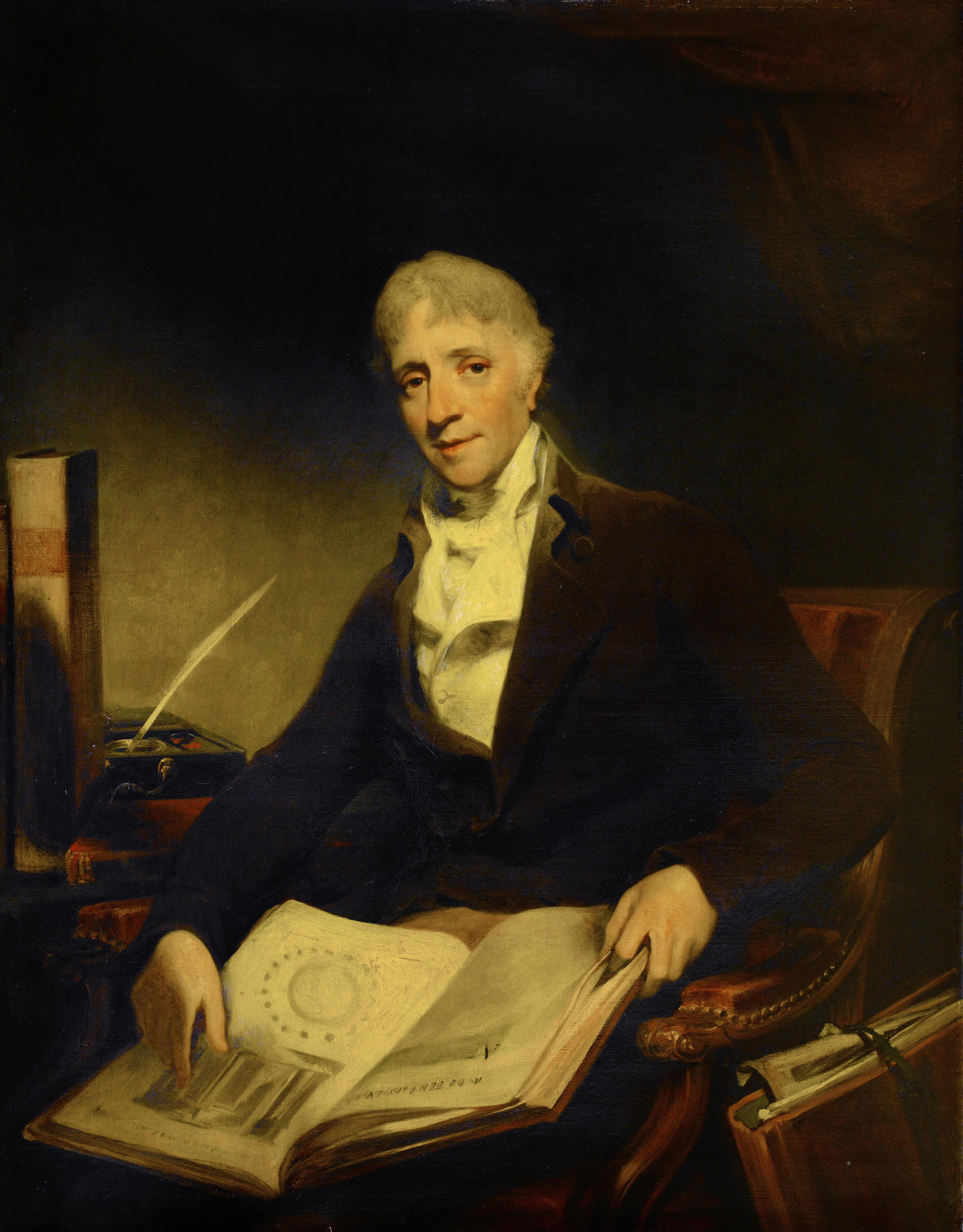 early nineteenth century oil painting of a grey-haired man in a white cravat and dark jacket seated on a chair with an open book about architecture on his lap, further volumes either side and a quill and ink well