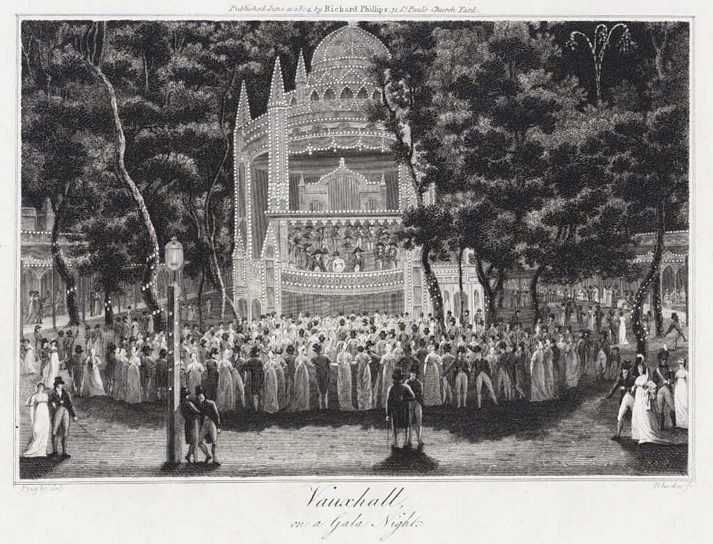 Black and white print from 1804 of Vauxhall on a gala night showing the three storey outdoor orchestra building lit up and a large audience gathered to enjoy the performance Trees surround the scene 